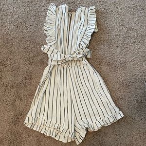 Size small Billabong romper with tie belt. Has ruffle detail on sleeves/shorts.
